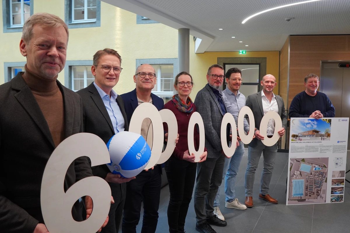 Das Projektteam hält die Zahl 6 Millionen in die Kamera